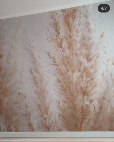 Die Wand zeigt eine sanfte, beige Grafik von Pflanzenmotiven.