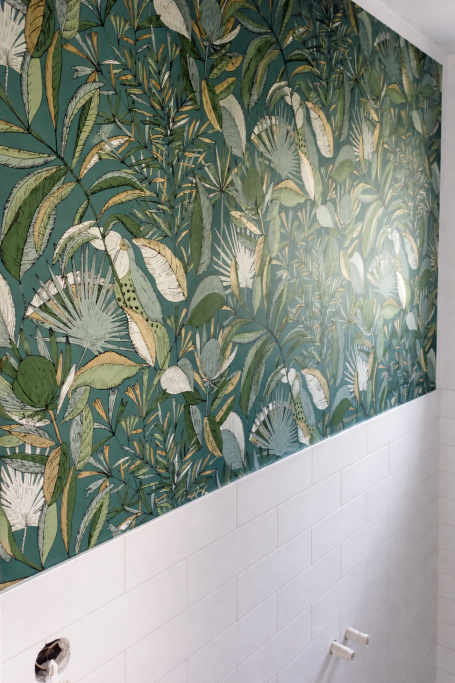 Wand mit grünem Pflanzenmuster und floralen Motiven.
